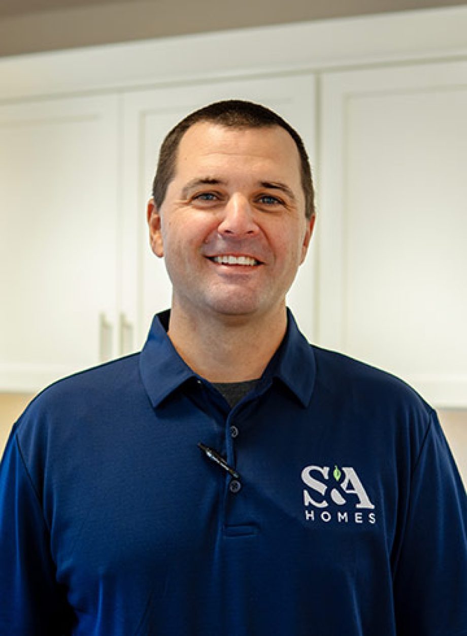 Chad Rimmey smiling indoors in a blue S&A Homes polo shirt