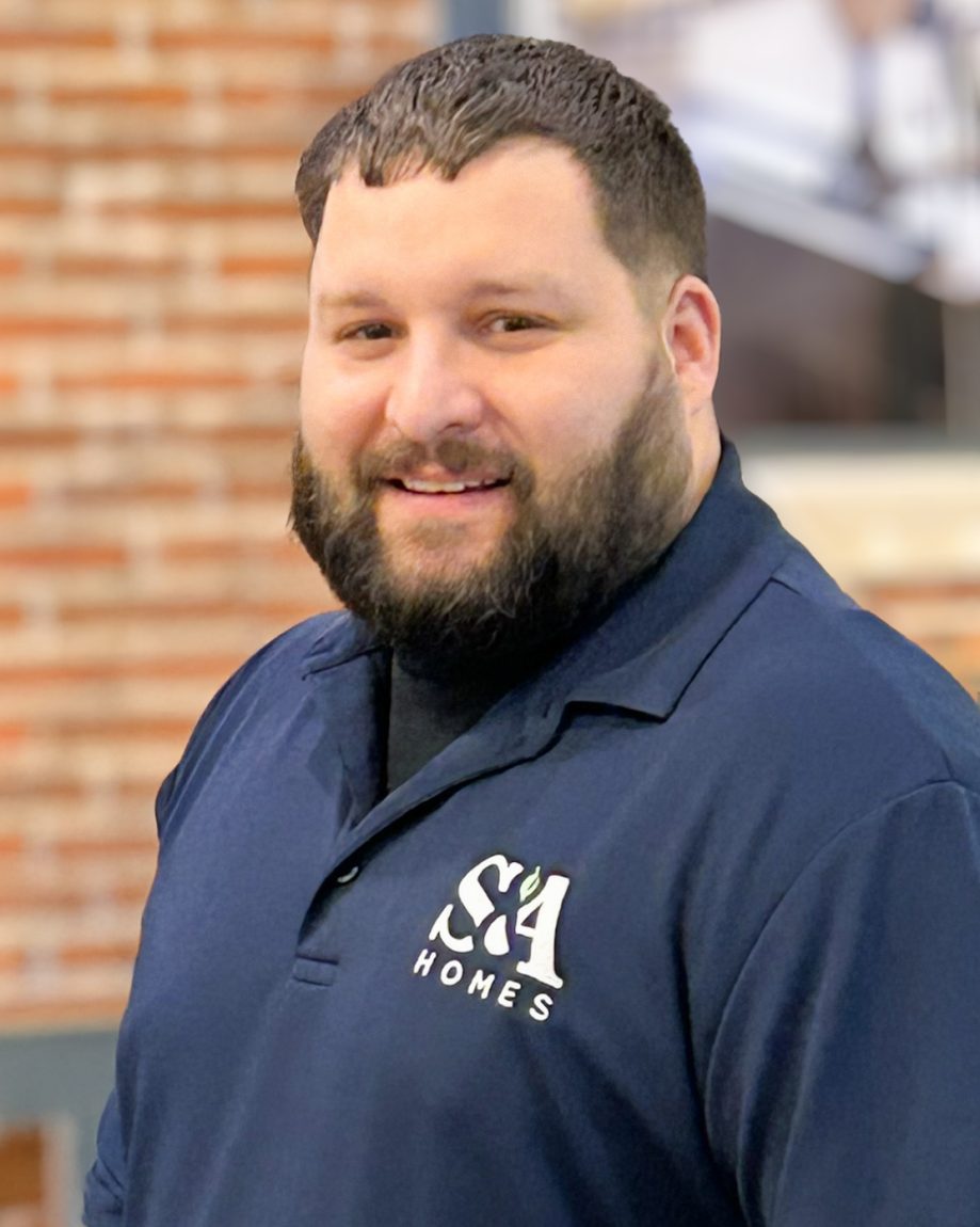 Josh McVey smiling indoors in a navy S&A Homes polo shirt